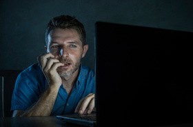 Mężczyzna cierpiący na seksoholizm ogląda w Internecie pornografię