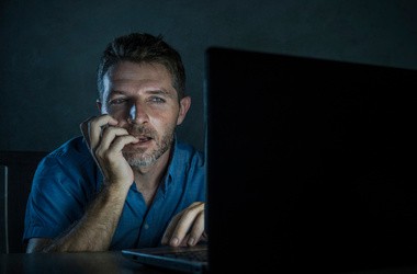 Mężczyzna cierpiący na seksoholizm ogląda w Internecie pornografię