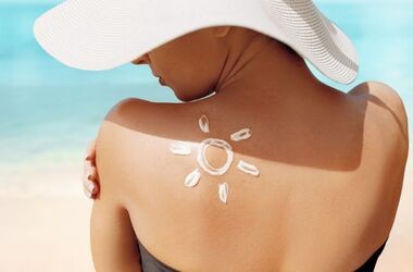 spf, wskaźnik spf, kobieta w kapeluszu na plaży wsmarowuje spf