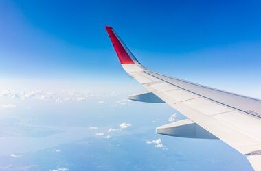 lot samolotem, widok z okna samolotu na skrzydło i niebo