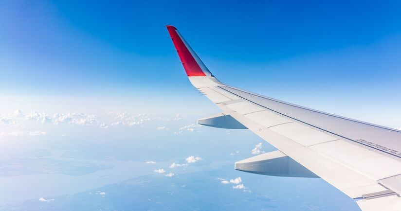 lot samolotem, widok z okna samolotu na skrzydło i niebo