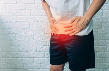 Mężczyzna trzymający się za bolące podbrzusze