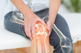 ból stawów, osoba z bakteryjnym zapaleniem stawów trzyma się za kolano