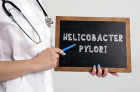 kobieta trzyma w rękach tabliczkę Helicobacter pylori