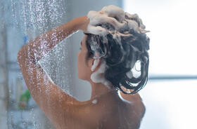 Kobieta myje włosy pod prysznicem