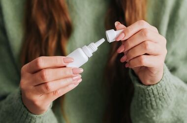 Kobieta trzymająca butelkę z kroplami do oczu, krople nawilżające do oczu, jak wybrać nawilżające krople do oczu