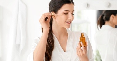 Kobieta aplikuje serum na skórę twarzy