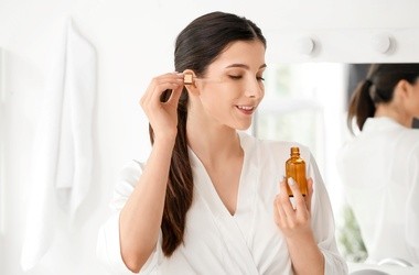 Kobieta aplikuje serum na skórę twarzy