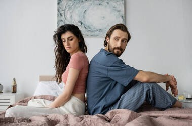 Aseksualna para siedzi plecami do siebie w łóżku