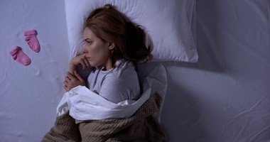 Kobieta na łóżka, która przeżywa poronienie dziecka