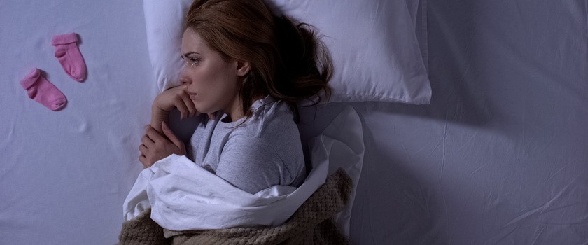 Kobieta na łóżka, która przeżywa poronienie dziecka