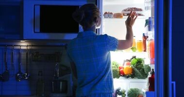 zespół nocnego jedzenia, nes, kobieta wyjmuje jedzenie z lodówki nocą