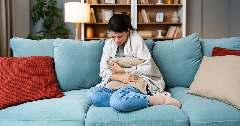 kobieta z bólem brzucha, bóle menstruacyjne, jak łagodzić bóle podczas miesiączki