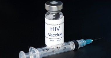 Fiolka ze szczepionką na HIV, obok której leży strzykawka z igłą