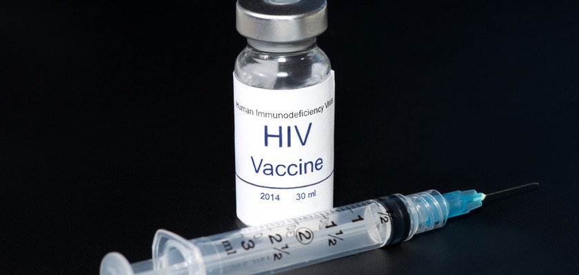 Fiolka ze szczepionką na HIV, obok której leży strzykawka z igłą