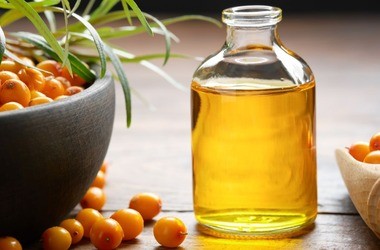 Olej z rokitnika w butelce, owoce rokitnika.