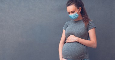 Kobieta w ciąży w maseczce zmagająca się z COVID-19