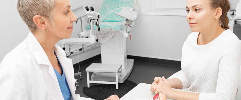 Kobieta z nadżerką szyjki macicy rozmawia z lekarzem w gabinecie ginekologicznym