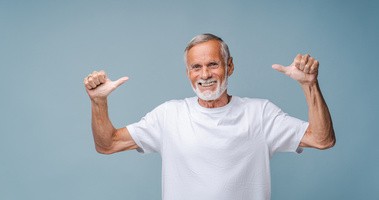 Starszy mężczyzna unosi ręce w geście zadowolenia
