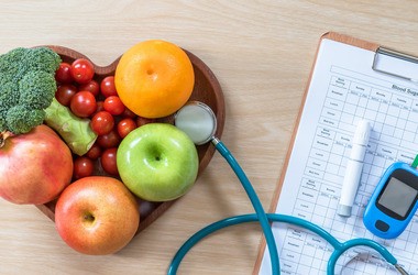 Owoce, stetoskop i glukometr leżą na drewnianym stole #cukrzyca