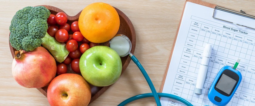 Owoce, stetoskop i glukometr leżą na drewnianym stole #cukrzyca