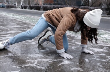 zimowe urazy, upadek na lodzie, kobieta upada na lodzie, śliski chodnik, oblodzone chodniki