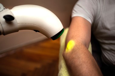 Zabieg z lampą bioptron u pacjenta cierpiącego na choroby stawów