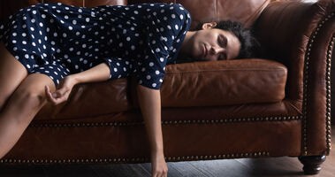 Kobieta cierpiąca na narkolepsję śpi na kanapie