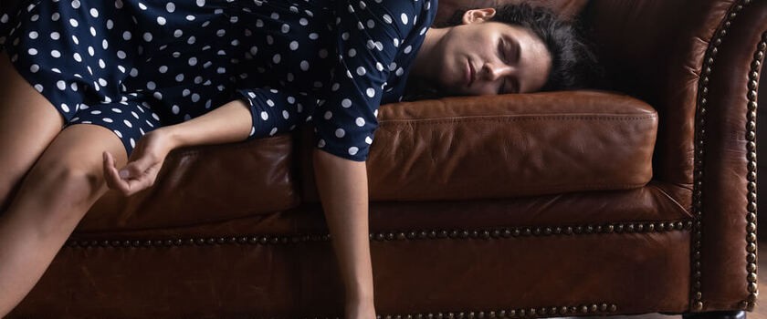 Kobieta cierpiąca na narkolepsję śpi na kanapie