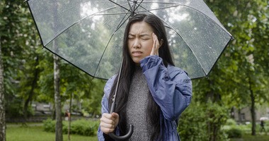Kobieta z parasolką cierpi na meteopatię