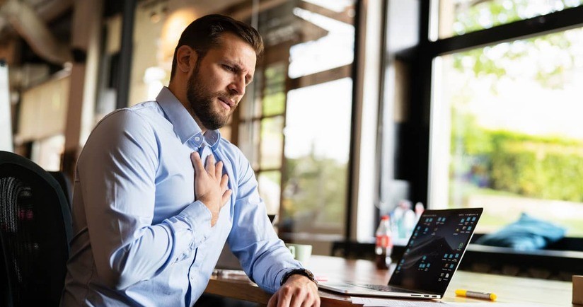 biznesman z bólem w klatce piersiowej