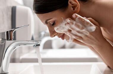 kosmetyki z sls, czy sls szkodzi, sls i sles, kobieta myje twarz nad umywalką