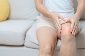 maść na ból stawów, maść na ból mięśni, kobieta smaruje maścią bolące kolano