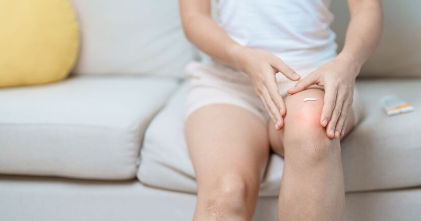 maść na ból stawów, maść na ból mięśni, kobieta smaruje maścią bolące kolano