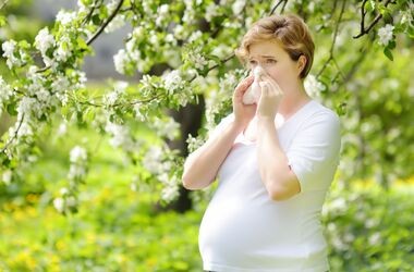 Kobieta w ciąży z alergią, objawiającą się katarem i kichaniem