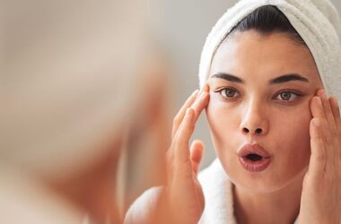 joga twarzy, joga na zmarszczki, jak ćwiczyć jogę twarzy, kobieta ćwiczy jogę twarzy w lustrze