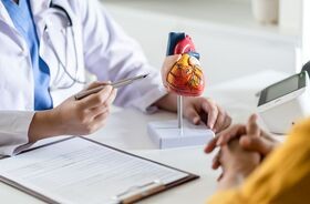 Kardiolog i pacjent przy biurku. Angioplastyka wieńcowa, angioplastyka tętnic.