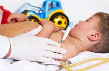 Medyk mierzy temperaturę dziecku z odrą. Ognisko odry na Podkarpaciu.