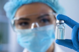 Kobieta biolog trzyma w dłoni fiolkę z substancją