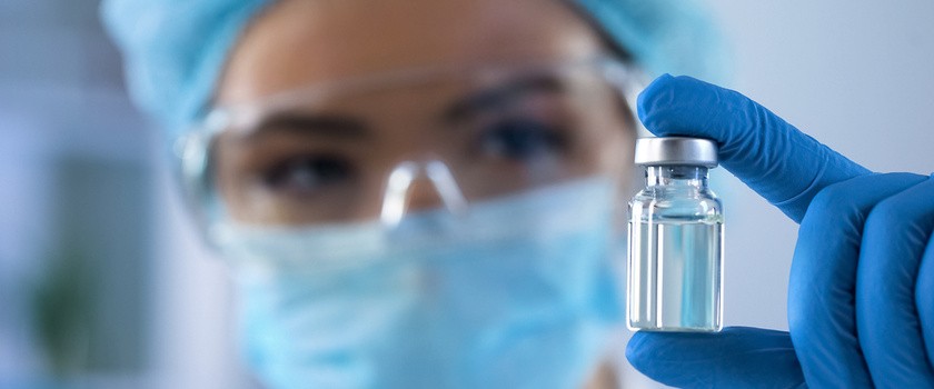 Kobieta biolog trzyma w dłoni fiolkę z substancją