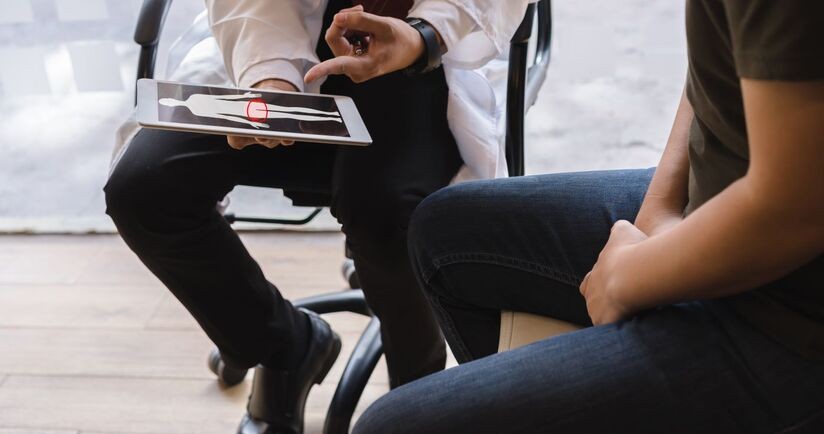 Mężczyzna konsultuje się z lekarzem w sprawie raka jąder. Nowotwór jądra, guz jądra, nowotwór złośliwy jądra.