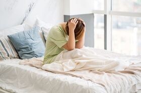 Kobieta cierpiąca na ból z tyłu głowy, ból głowy z tyłu, ból głowy i karku, ból potylicy.