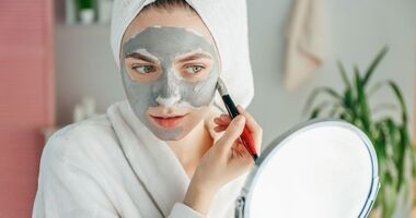 domowe sposoby an trądzik, domowe maseczki, maska z glinki na trądzik, kobieta nakłada maseczkę z glinki