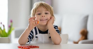 dziecko z witaminą w ręku, suplementy i witaminy na odporność, jak uniknąć infekcji