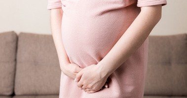 Kobieta w ciąży, trzymająca się za podbrzusze