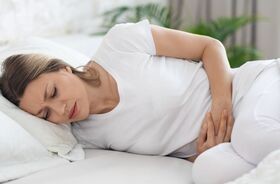 endometrioza, dieta przy endometriozie, kobieta z bólem podbrzusza na łóżku