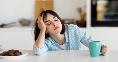 przewlekła bezsenność, związek bezsenności z demencją, niewyspana młoda kobieta pije kawę, problemy ze snem