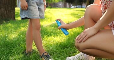 kobieta pryska dziecko repelentem, repelenty bezpieczne dla dzieci, repelenty dla dzieci, środki na komary dla dzieci, co przeciw komarom dla dziecka