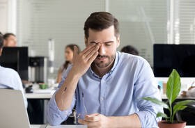 Mężczyzna zmęczony na skutek zespołu chronicznego zmęczenia w miejscu pracy