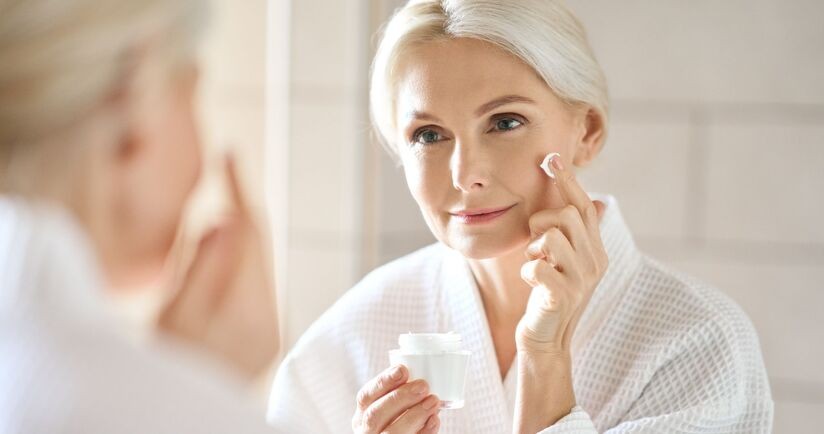 heksapeptyd, heksapeptydy na zmarszczki, produkty anti-aging, kobieta po 50-tce nakłąda krem z heksapeptydami